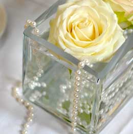 Roses and pearls in glass cube