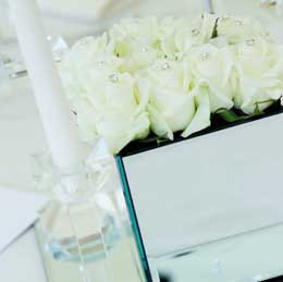 White roses in mirrored cube
