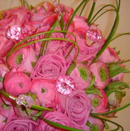 Pink roses and ranunculas in a handtied bridal bouquet